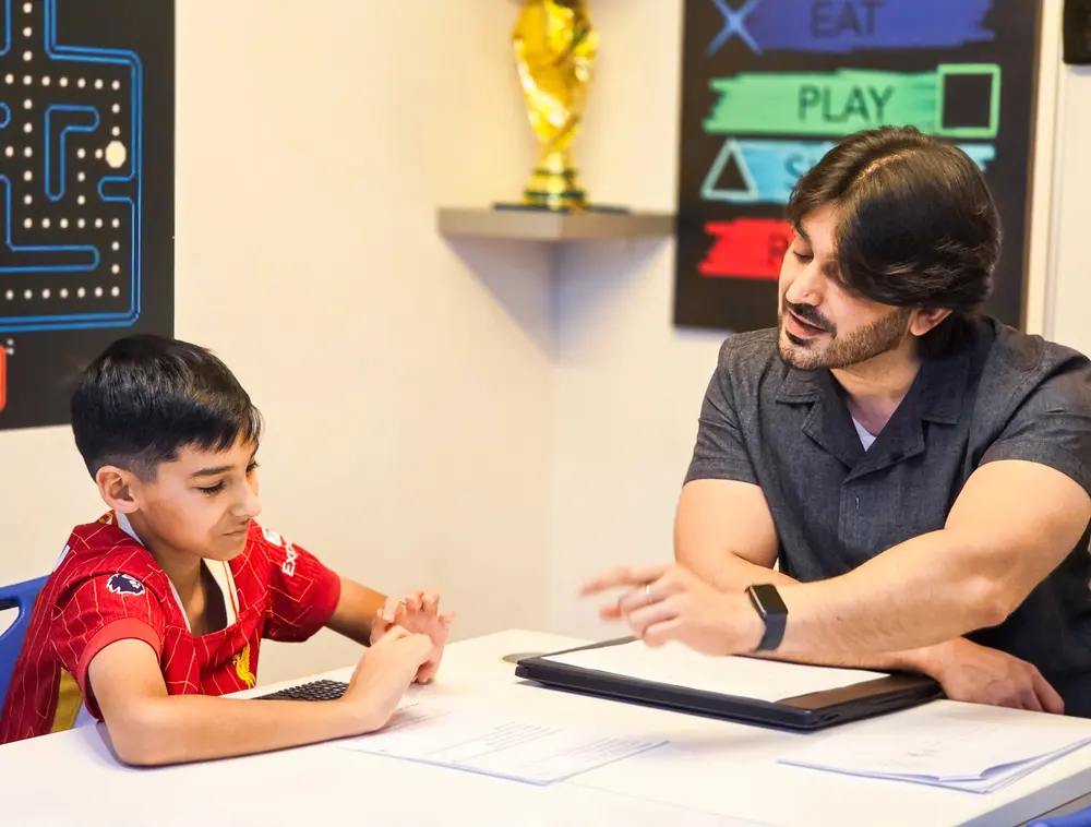 Primary student working through maths with his tutor at Improve ME Institute