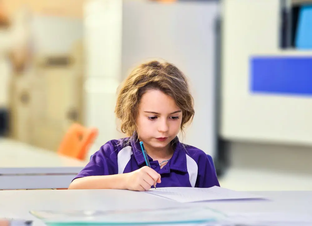 Year 3 student concentrating on a maths task at Improve ME Institute