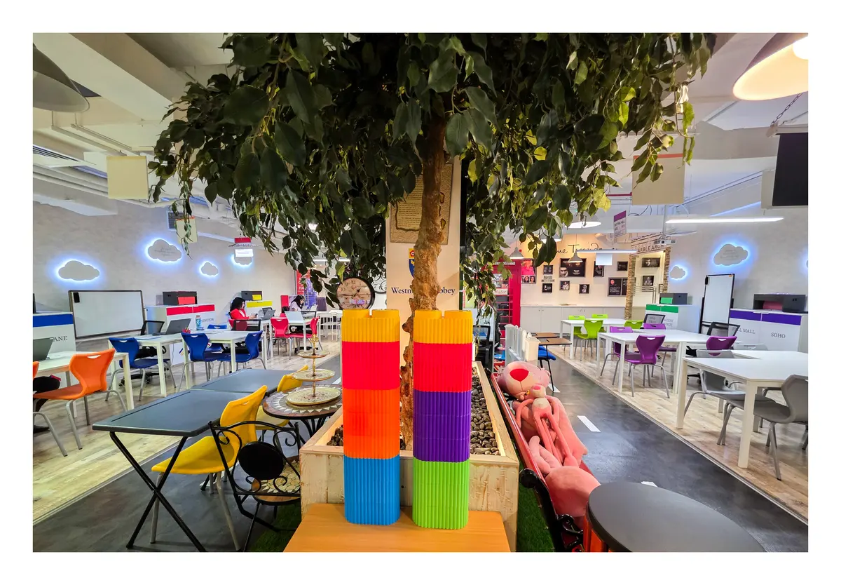 Colourful play and study area under an indoor tree at Improve ME Institute
