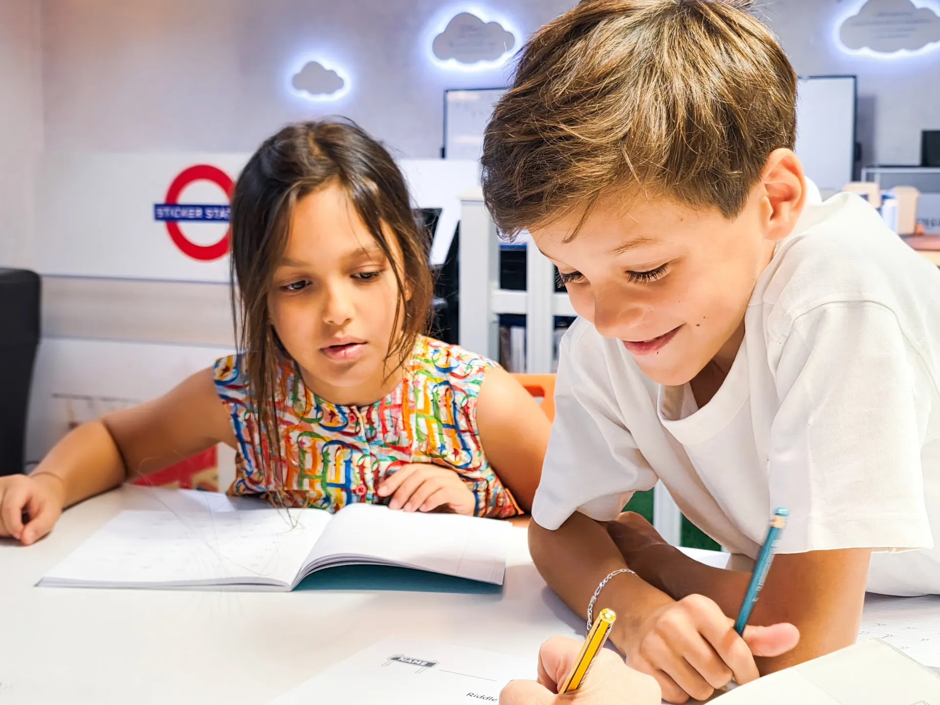 Two students smiling and concentrating on their work at Improve ME Institute, Dubai