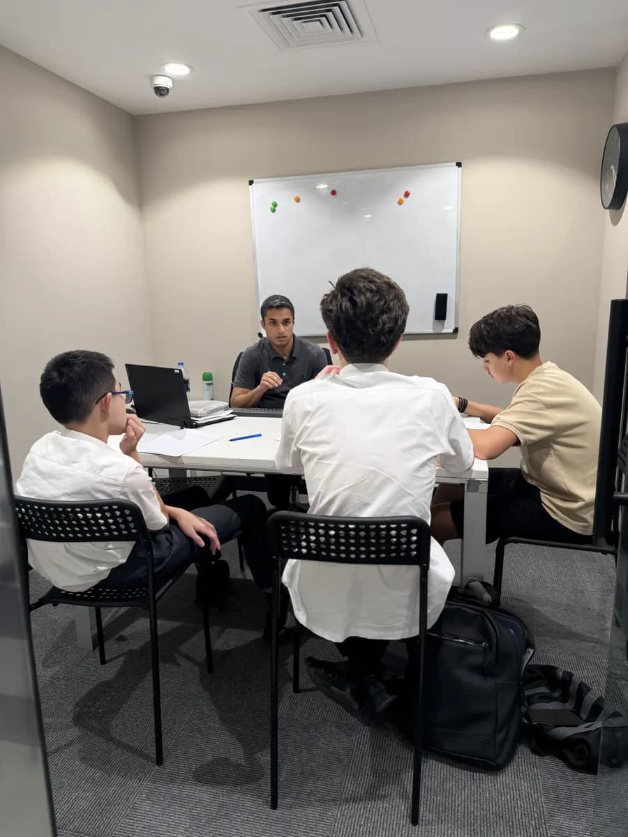 Older students working together with their teacher in a small-group examination preparation session.