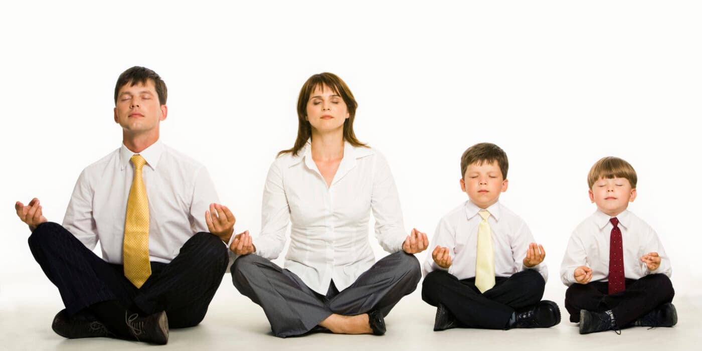 A family meditating together in a row